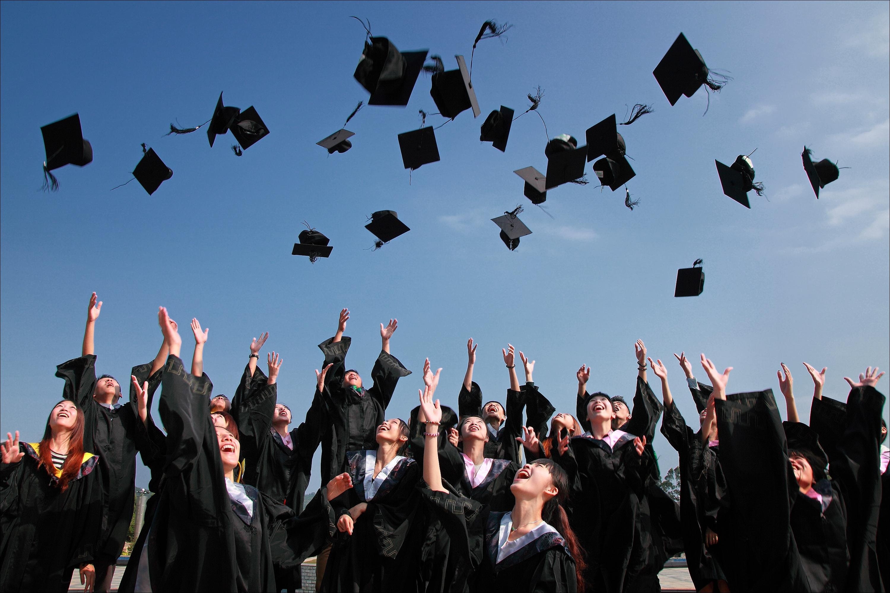 A group of graduations tossing caps in the air